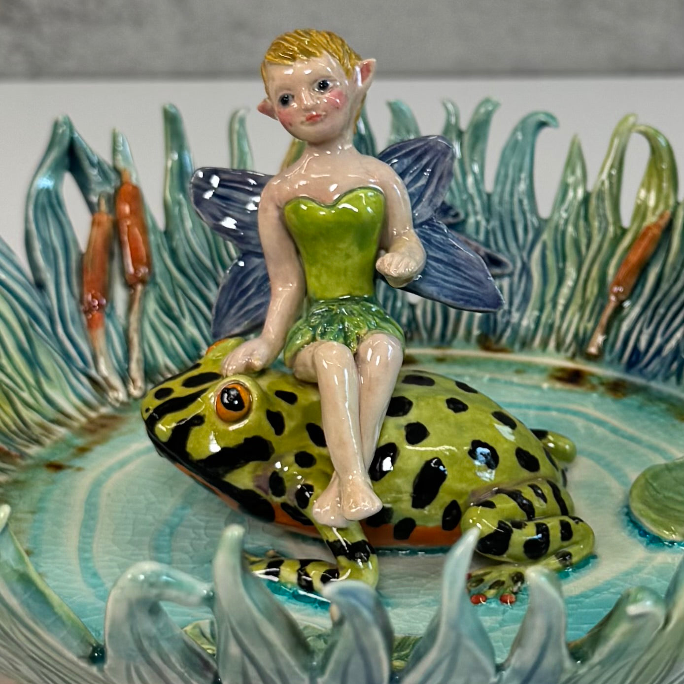 03 Fairy riding a fire bellied toad in a pond - White Stoneware